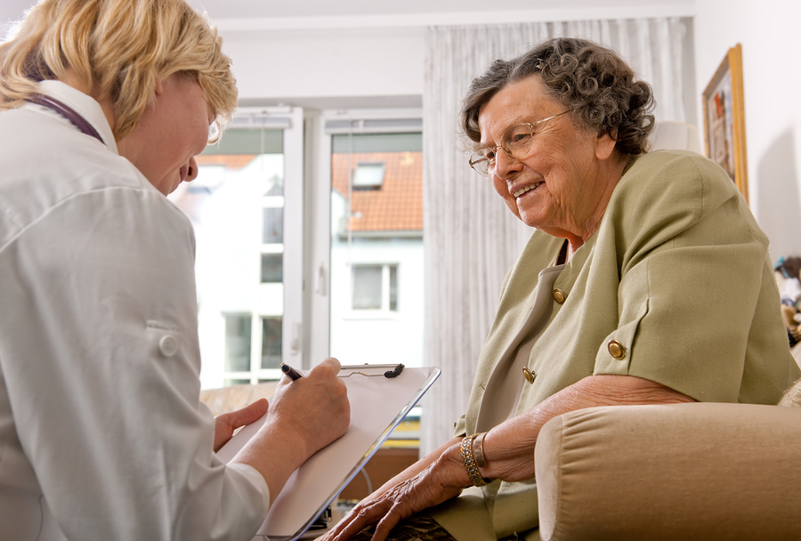 Senior woman is visited home by her doctor or caregiver at home