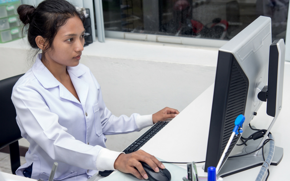 A medical office assistant is at work on a computer