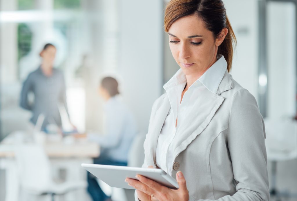 A woman looks at her tablet during a meeting